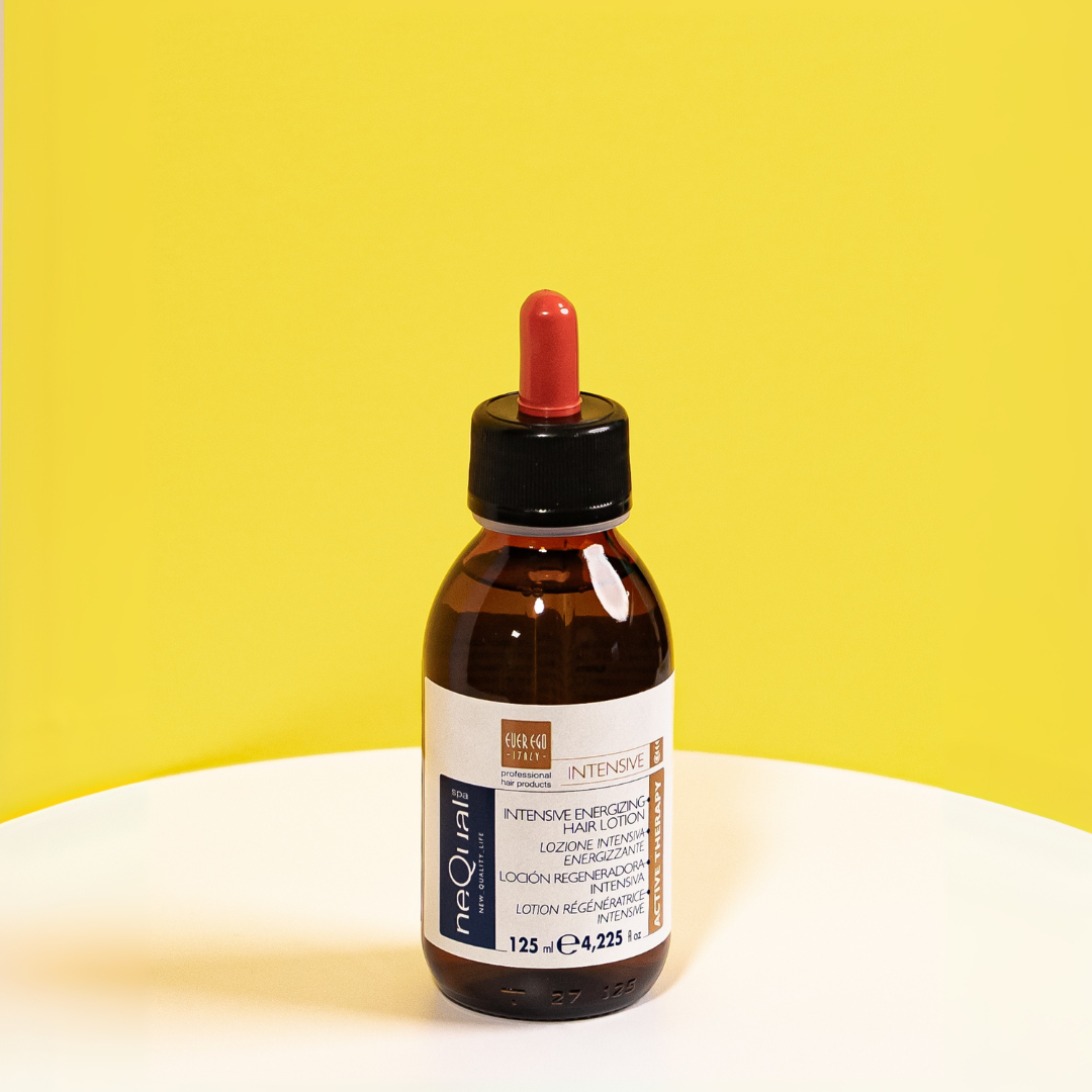 Intensive energizing hair lotion in amber bottle with dropper, yellow background